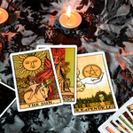 Three tarot cards displayed next to candles.