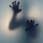Spooky hands against clouded glass.